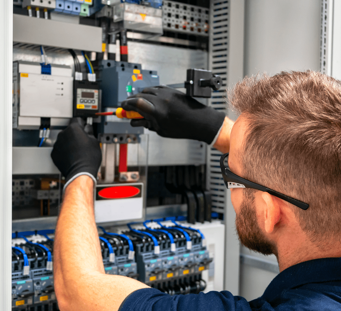 Electrician repairing a circuit breaker inside an electrical panel.